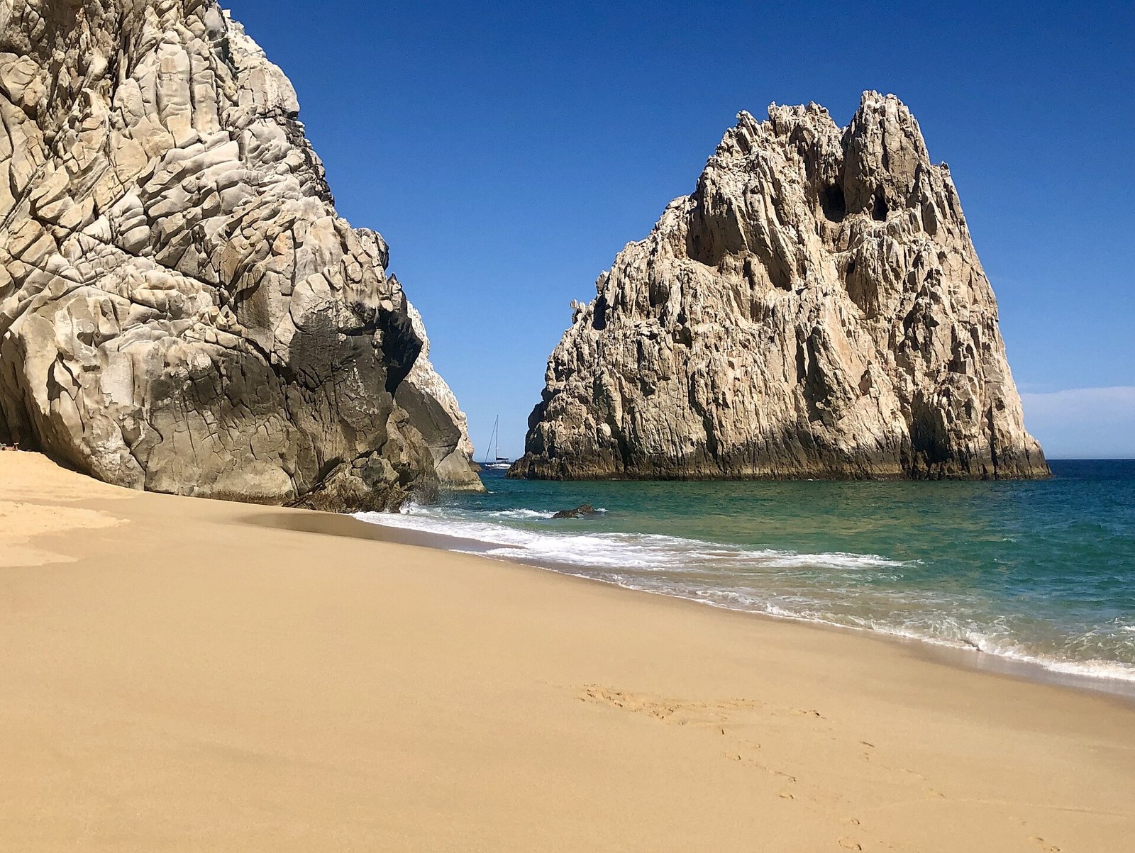 Pacific surf rolling onto Divorce Beach between tall granite rocks at Land's End, Cabo San Lucas